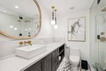 Luxurious master bath with marble tile and gold faucets